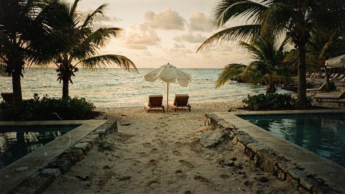 Sand path leading from a family resort pool deck to the shoreline at low evening light